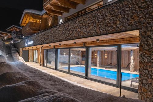 a house with a swimming pool inside of it at Natursinn Mountainchalets in Flachau