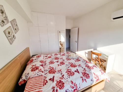 een slaapkamer met een bed met een rode en witte deken bij City View Rooms in Larnaka