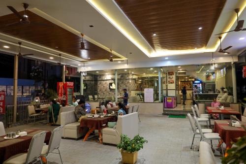 un restaurante con mesas y sillas y gente en él en Hotel Sai Bansi, en Shirdi