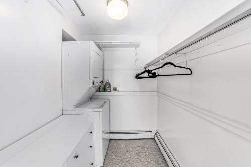 a white hallway with white cabinets and a light fixture at Mill Run 3D in Quechee