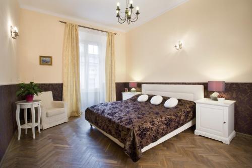 a bedroom with a bed and a chair at Apartamenty Gołębia 3 in Krakow