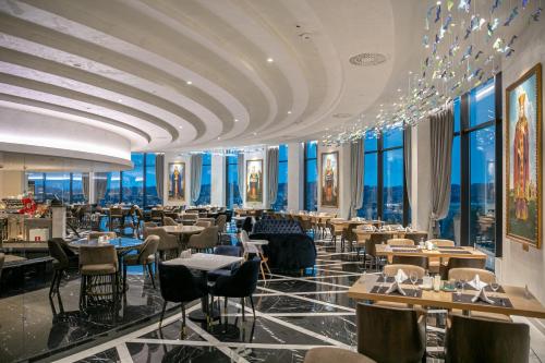 un restaurant avec des tables, des chaises et des fenêtres dans l'établissement A Hoteli - Grand&Sky Hotel Tornik, à Zlatibor