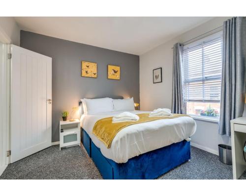 a bedroom with a large bed with a yellow blanket at Central Belfast Apartments Ravenhill in Belfast