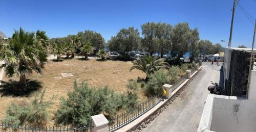 a view of a park with trees and a fence at Beach apartment Edem first floor in Perivolos
