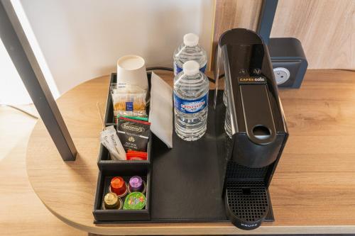 a blender sitting on top of a table with water bottles at B&B HOTEL Epernay in Épernay