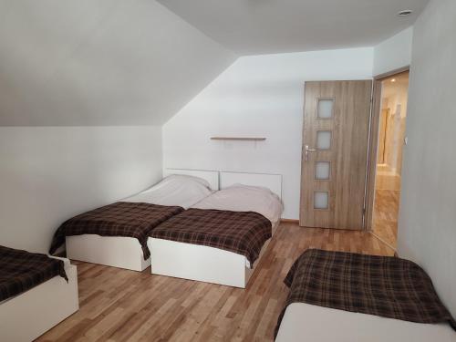 sypialnia z 2 łóżkami i drewnianą podłogą w obiekcie Agrowczasy Nad Stawem w mieście Gartatowice