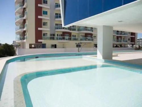 una gran piscina frente a un edificio en Excelente Apartamento em Cabo Frio, en Cabo Frío