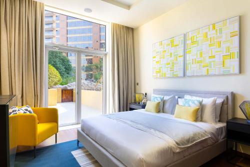 una camera con un grande letto e una sedia gialla di Tiara Beach Residences, Palm Jumeirah Dubai - Mint Stay a Dubai