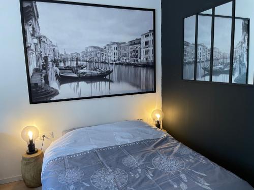a bedroom with a bed with a picture on the wall at Très Grand Studio - Terrasse in Strasbourg