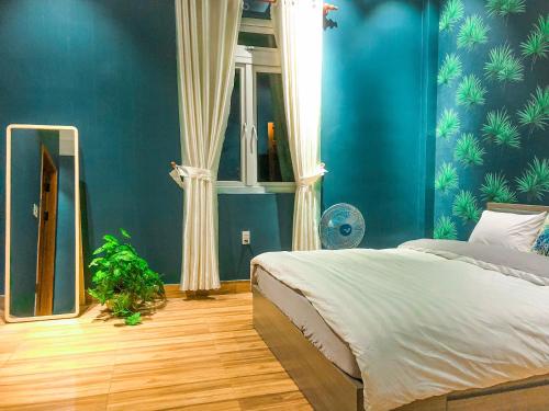 a bedroom with blue walls and a bed with a mirror at Mooka 's Home (Backpackers) in Da Lat