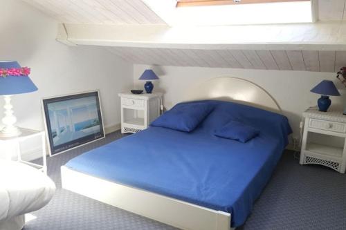- une chambre avec un lit bleu et une télévision dans l'établissement les hauts de st clair,vue mer et vert,tres calme, au Lavandou
