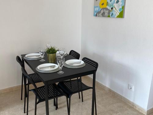 una mesa negra con sillas, platos y copas de vino en Montgo 2 Bellreguard, en Bellreguart
