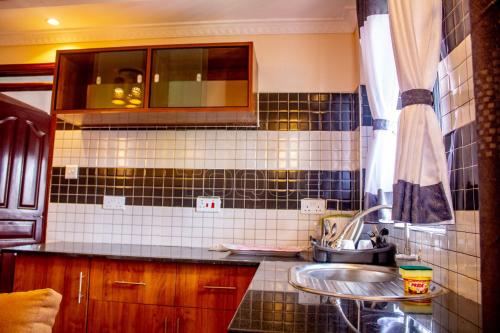 cocina con fregadero y pared de azulejos en Toque Hotel, en Nairobi