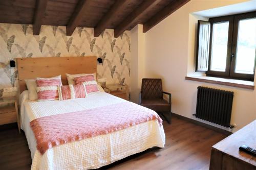 a bedroom with a bed with pink and white sheets at Eguen Goiko in Lekeitio