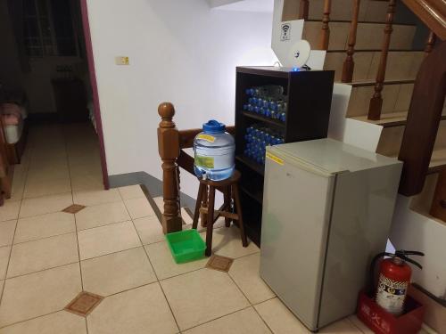a kitchen with a small refrigerator and a stool at Fire B&B in Chishang