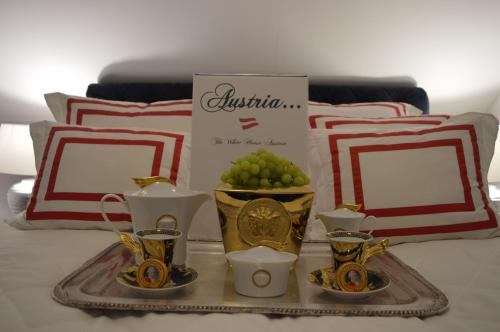 uma bandeja com vasos e chávenas numa cama em The White House Austria em Lind ob Velden