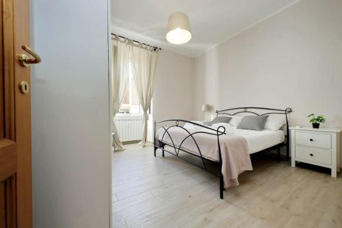 a white bedroom with a bed and a window at Casa Testaccio in Rome