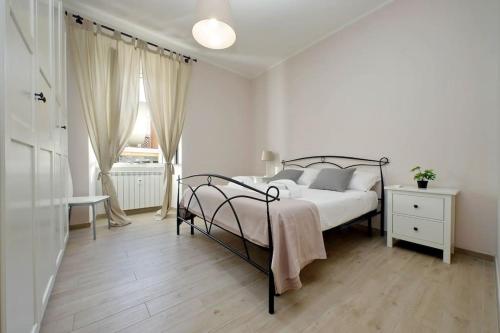 a white bedroom with a bed and a window at Casa Testaccio in Rome