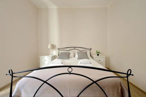 a white bedroom with a bed with a black frame at Casa Testaccio in Rome