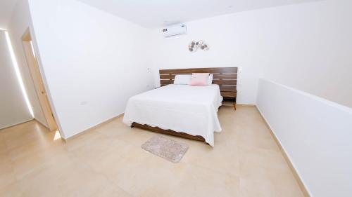 ein Schlafzimmer mit einem Bett in einem weißen Zimmer in der Unterkunft Beautiful LOFT in front of Wyndham Hotel in Manta