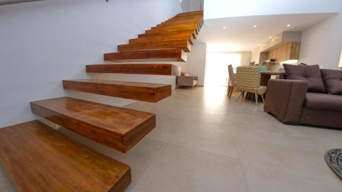 a living room with wooden stairs and a couch at Beautiful LOFT in front of Wyndham Hotel in Manta