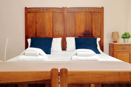 ローマにあるCasa Testaccioのベッドルーム1室(大型木製ベッド1台、青い枕付)