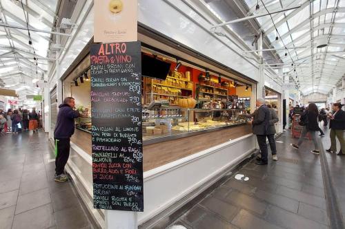 a group of people standing in a food market at Casa Testaccio in Rome