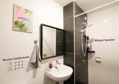 een badkamer met een wastafel en een spiegel bij H2H - CosyStay @ Majestic Ipoh Town Central in Ipoh