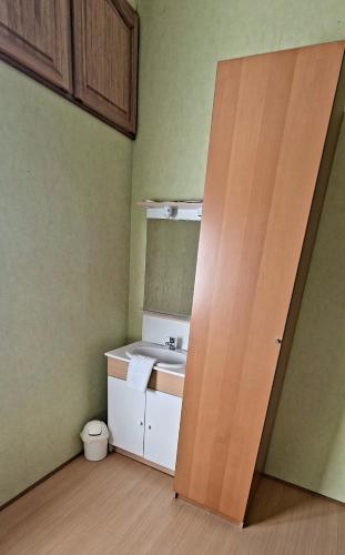 une salle de bain avec un lavabo et un miroir dans l'établissement Chambres d hôtes Le Bois Corbeau, à Tiffauges