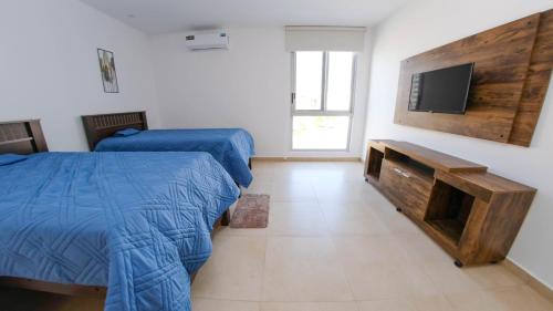 1 dormitorio con 2 camas y TV de pantalla plana en Hermosa Casa en Via Barbasquillo, en Manta