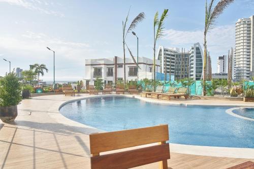 a swimming pool with a bench in a city at Urbanización privada, seguridad y confort in Manta