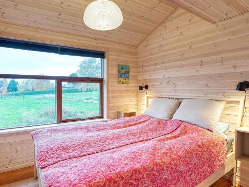 a bedroom with a bed and a large window at Holiday home Stubbekøbing VII in Stubbekøbing