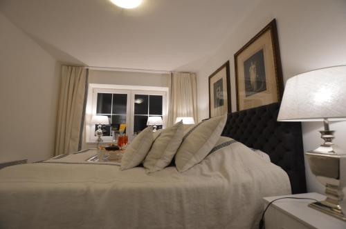 a bedroom with a large bed with pillows on it at The White House Austria in Lind ob Velden