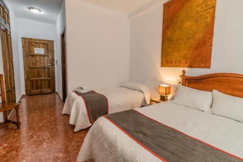 a hotel room with two beds and a door at Hotel Las Errizas by Vivere Stays in Alcalá del Valle