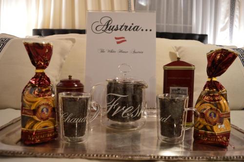 a tray with two bottles and two glasses on a table at The White House Austria in Lind ob Velden