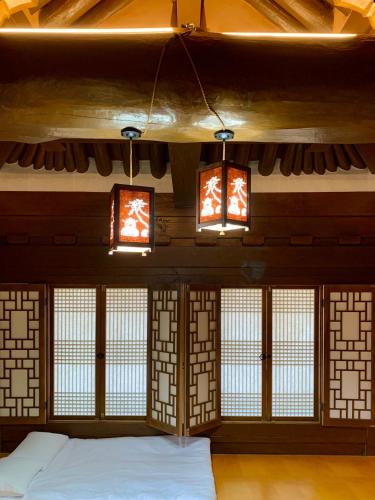 a room with a bed in a room with windows at HanokInn in Gyeongju