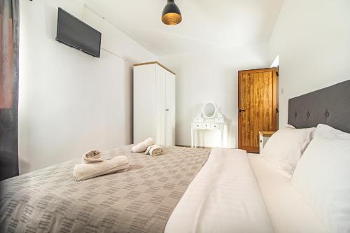Un dormitorio blanco con una cama con toallas. en Boutique Hotel Ilitsa 