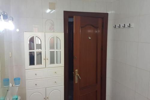Łazienka z drewnianymi drzwiami i białą szafką w obiekcie Kaz Bedrooms w Maladze