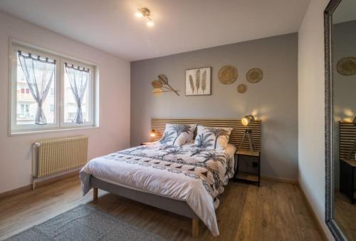 a bedroom with a bed and a desk and windows at Appartement Le Saver'Zaru, centre ville, T2 55m² in Saverne