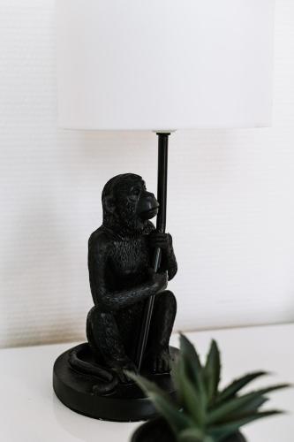 a black figurine of a monkey holding a lamp at Bienvenue chez Noémie - Arrivée Autonome in Châtellerault