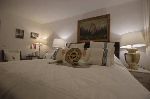 a bedroom with a large white bed with pillows at The White House Austria in Lind ob Velden