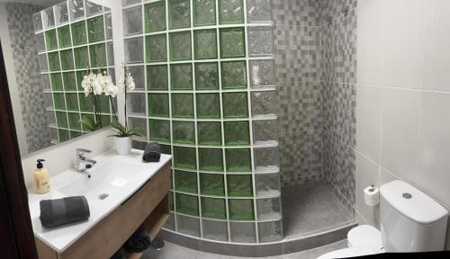 baño con lavabo y ducha con azulejos verdes en Casa Sol y Luna, en Costa Calma