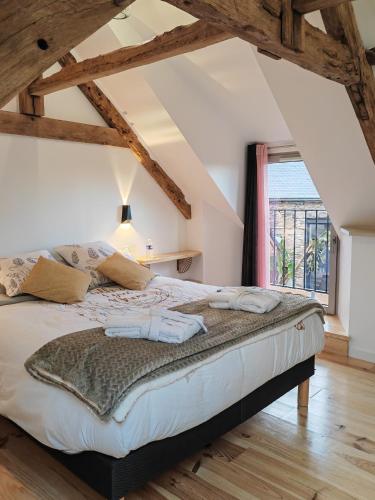 un grand lit dans une chambre avec une fenêtre dans l'établissement A La Mémoire de Merlin 