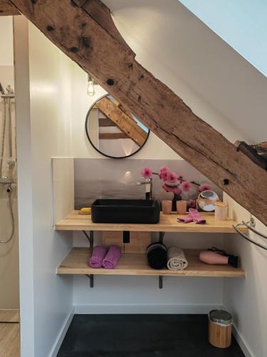 - une salle de bains avec une étagère sous les escaliers dans l'établissement A La Mémoire de Merlin 