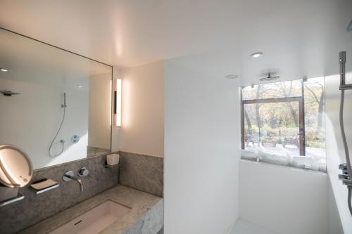 a bathroom with a shower with a sink and a mirror at Luxury Glamping Room8 a private hideaway from Brussels in Huldenberg