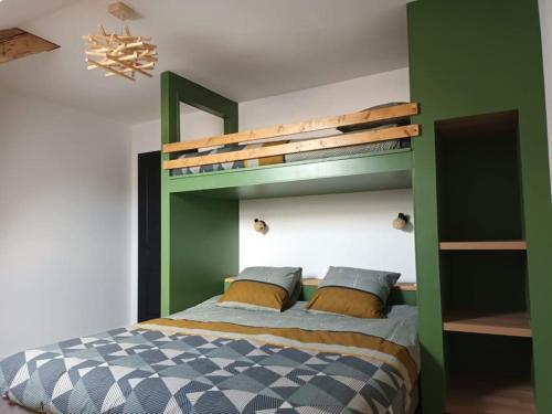 een slaapkamer met een groen stapelbed met 2 kussens bij Appt centre Gerardmer in Gérardmer