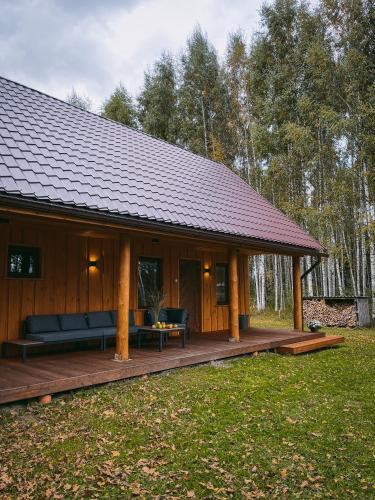 a large wooden cabin with a large deck at MI namiņš in Robežnīca