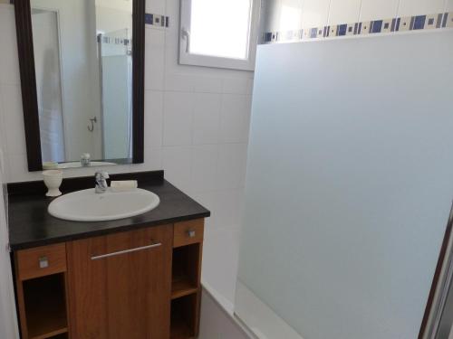une salle de bain avec un lavabo et un miroir dans l'établissement Appartement Pour 4 Personnes- Residence L accalmie, à Capbreton