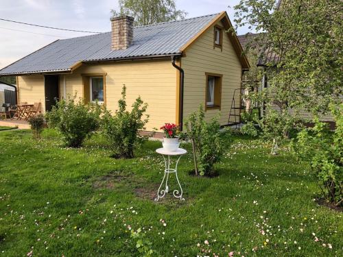 a small yellow house with a table in the yard at Uku Villa in Pärnu