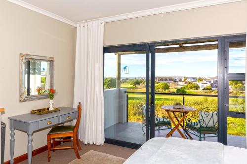 a bedroom with a desk and a window with a view at Le Mahi Guest House in Langebaan